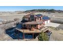 Aerial elevation showcasing wrap around deck, solar panels, and two-car garage at 4586 Best Rd, Larkspur, CO 80118