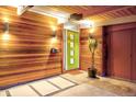 Inviting entryway featuring warm wood accents, a bright green door, and modern lighting at 1497 S Fairfax St, Denver, CO 80222