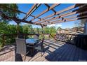 Outdoor deck featuring an attractive pergola, dining table, and stairs to the back yard at 1424 Cypress Cir, Lafayette, CO 80026