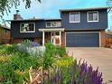 Stylish two-story home with brick accents, complemented by a colorful and well-maintained landscaped garden at 1424 Cypress Cir, Lafayette, CO 80026