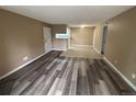Open-concept living room with modern flooring that flows into a tiled kitchen space at 910 S Walden St # 101, Aurora, CO 80017