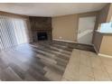 Spacious living room featuring a stone fireplace, wood flooring, and sliding door to a balcony at 910 S Walden St # 101, Aurora, CO 80017