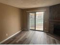 Bright living area with stone fireplace and sliding doors to a balcony with a view at 910 S Walden St # 101, Aurora, CO 80017