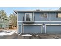 Exterior view of townhome garages, showcasing individual units with a small balcony above the center garage at 1289 S Wheeling Way, Aurora, CO 80012