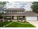 Two-story house with landscaped yard and attached garage at 5877 S Fulton Way, Greenwood Village, CO 80111