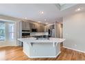 Beautiful kitchen with stainless steel appliances, a large island, and hardwood floors at 3097 Madison Ln, Broomfield, CO 80023