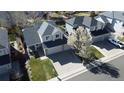 Aerial view of a two-story home with a three-car garage, a landscaped yard, and a beautiful flowering tree at 5654 S Zante Cir, Aurora, CO 80015