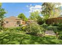 Beautiful backyard featuring a patio and lush landscaping, all set against the backdrop of mature trees at 4425 Irving St, Denver, CO 80211