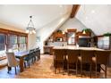Open kitchen with granite counters, wood beams, an island with bar seating, and an adjacent dining area at 302 N Main St, Breckenridge, CO 80424