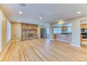 Inviting living room featuring hardwood floors, a stone fireplace, and an open kitchen concept at 7118 W Elmhurst Ave, Littleton, CO 80128