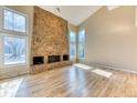 Bright living room with a stone fireplace, hardwood floors, and an abundance of natural light at 7118 W Elmhurst Ave, Littleton, CO 80128