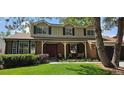 Charming two-story home with brick facade, covered porch, bay window and well-maintained lawn at 7655 S Ogden Way, Centennial, CO 80122
