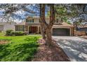 Beautiful two-story home featuring a brick facade, an attached garage and a well-manicured lawn at 7655 S Ogden Way, Centennial, CO 80122