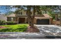 Lovely two-story home with a brick facade, mature trees, well manicured lawn and black garage doors at 7655 S Ogden Way, Centennial, CO 80122