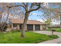 Charming brick home with a well-manicured lawn, mature trees, and a cozy front porch at 1002 Zang St, Golden, CO 80401