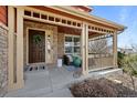 Inviting front porch featuring stone accents, a cozy seating area, and a welcoming entrance at 23101 Timber Spring Ln, Parker, CO 80138