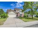 Charming two-story home with a well-manicured lawn, driveway, and attached two-car garage at 9946 Harrison St, Thornton, CO 80229