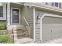 Welcoming front entrance with grey siding, steps to the front door, and an attached two car garage at 12256 Utica St, Broomfield, CO 80020