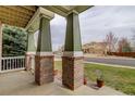 Welcoming covered porch with brick columns and a cozy neighborhood view at 1348 Lawson Ave, Erie, CO 80516