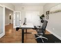 Another view of the well lit office with hardwood floors and a modern adjustable height desk at 3427 S Cherry St, Denver, CO 80222