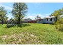 Expansive backyard with a grassy lawn, deck and a swing set, perfect for outdoor enjoyment at 1204 S Salida Way, Aurora, CO 80017