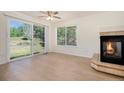 Living room with a fireplace, a ceiling fan, and large glass doors leading to a fenced backyard at 4697 Waldenwood Dr, Highlands Ranch, CO 80130