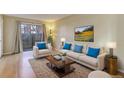 Bright living room with modern furniture, plush seating, and sliding glass doors to a patio at 9356 W Utah Pl, Lakewood, CO 80232