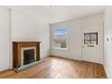 Bright living room featuring hardwood floors, a decorative fireplace, and a large window at 4240 N Clay St, Denver, CO 80211