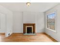 Bright living room featuring hardwood floors, a decorative fireplace, and a large window at 4240 N Clay St, Denver, CO 80211