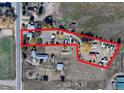 Aerial view of the property, bordered in red, displaying its layout, outbuildings, and surrounding landscape at 7750 Indiana St, Arvada, CO 80007
