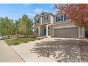 Inviting two-story home with well-maintained lawn, blue shutters, and a spacious driveway leading to the garage at 1558 Wandering Way, Castle Rock, CO 80109