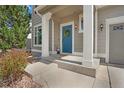Inviting front porch featuring a blue door with a wreath and white columns supporting the covered entrance at 1558 Wandering Way, Castle Rock, CO 80109