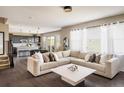 Spacious living room showcasing a comfortable sectional sofa, hardwood floors, and seamlessly connected with a modern kitchen at 14807 Haley Ave, Parker, CO 80134