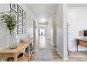 Bright and spacious hallway with hardwood floors and decorative accents leading to dining area at 12759 Buffington Trl, Parker, CO 80134