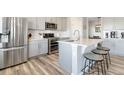 Modern kitchen with stainless steel appliances, gray cabinetry, quartz countertops, and a breakfast bar at 12759 Buffington Trl, Parker, CO 80134