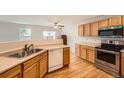 Kitchen features stainless steel appliances, wood cabinets, and hardwood floors at 5522 S Quemoy Cir, Aurora, CO 80015