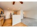 Open-concept living area with hardwood floors in kitchen and carpet in living area at 5522 S Quemoy Cir, Aurora, CO 80015