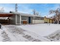 Ranch style home with gray siding, snowy front yard, and a covered carport at 5332 Granby St, Denver, CO 80239