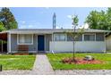 Well-maintained gray home with a blue door, green lawn, and decorative landscaping at 5332 Granby St, Denver, CO 80239