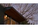 Close-up of a balcony and the angle of the roof line during dusk under a bare tree at 2890 S Sherman St, Englewood, CO 80113