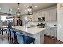 Modern kitchen with white countertops, pendant lighting, and stainless steel appliances at 635 Silver Rock Trl, Castle Rock, CO 80104
