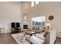 Bright living room features a fireplace, large windows, and high ceilings at 635 Silver Rock Trl, Castle Rock, CO 80104