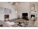 Open concept living area with fireplace, high ceiling, and modern decor at 635 Silver Rock Trl, Castle Rock, CO 80104