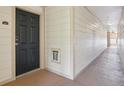 Well-lit hallway with clean white walls leading to a unit with a secure black door at 5726 N Genoa Way # 301, Aurora, CO 80019