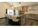 Modern kitchen with stainless steel appliances, large island with seating, and custom cabinetry at 9768 Otis Dr, Westminster, CO 80021