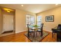 Dining area with hardwood floors, view of front yard, and a modern glass table at 7661 Chickaree Ct, Littleton, CO 80125
