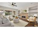 Bright living room with stone fireplace, stylish furniture, and hardwood floors at 15980 Pikes Peak Dr, Broomfield, CO 80023