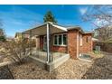 Brick exterior with a covered porch and tidy landscaping features at 1386 S Garfield St, Denver, CO 80210