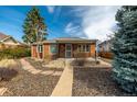 Quaint brick house showcasing a cozy covered porch and a mature shade tree at 1386 S Garfield St, Denver, CO 80210
