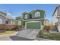 Green two-story home features a two-car garage and front yard with mature landscaping at 2116 W 101St Cir, Thornton, CO 80260